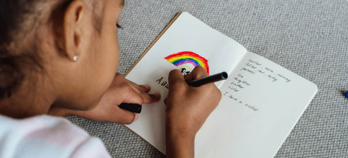Child writing a letter by hand in a notebook.